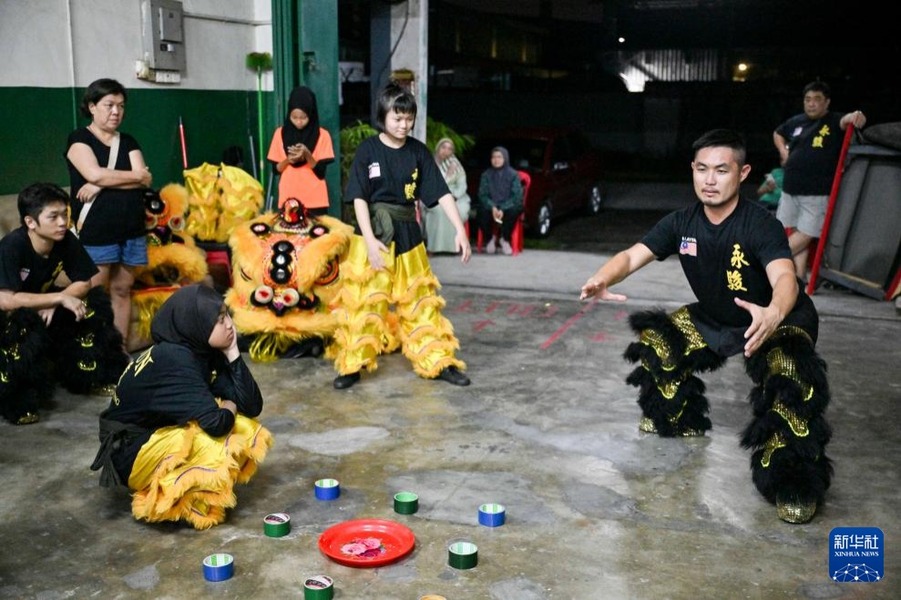 9月8日，在馬來(lái)西亞雪蘭莪州的萬(wàn)饒，永駿醒獅團(tuán)師父陳永證（右）為團(tuán)隊(duì)下周的表演活動(dòng)進(jìn)行最后的示范和囑咐。新華社記者 程一恒 攝