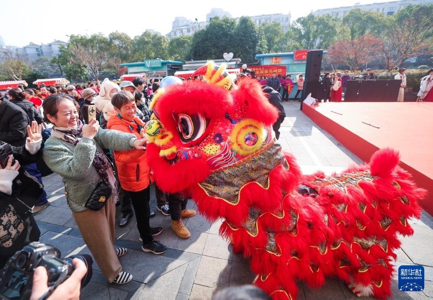 12月31日，舞獅隊在年貨節(jié)現(xiàn)場與市民游客互動。