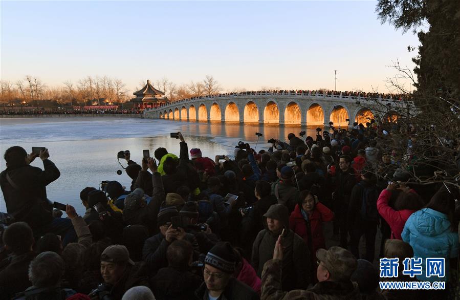 12月23日，游客和攝影愛好者在拍攝頤和園十七孔橋“金光穿洞”美景。 當(dāng)日，北京頤和園十七孔橋出現(xiàn)“金光穿洞”美景，吸引許多游客和攝影愛好者前來觀賞拍攝。 新華社記者陳曄華攝