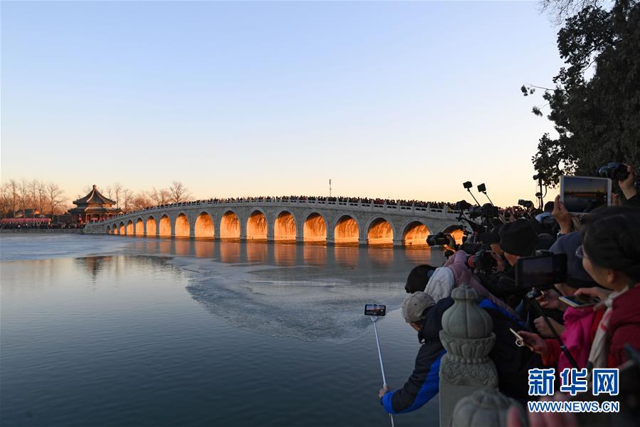 12月23日，游客和攝影愛好者在拍攝頤和園十七孔橋“金光穿洞”美景。 當(dāng)日，北京頤和園十七孔橋出現(xiàn)“金光穿洞”美景，吸引許多游客和攝影愛好者前來觀賞拍攝。 新華社記者陳曄華攝