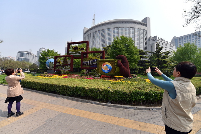 4月17日，路人用手機(jī)拍攝一帶一路主題花壇。