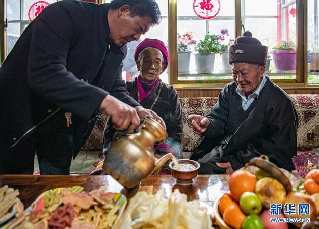 家人為昂旺尼瑪（右一）倒甜茶（2月18日攝）。