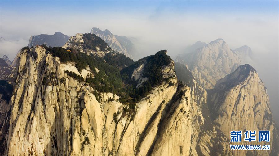 4月10日拍攝的華山東峰（右）與南峰（左）（無人機照片）。

位于陜西省華陰市的西岳華山，被稱為“奇險天下第一山”。據(jù)了解，華山將于4月11日起恢復開放，每日最大游覽接待量不超過6000人。 新華社記者 陶明 攝