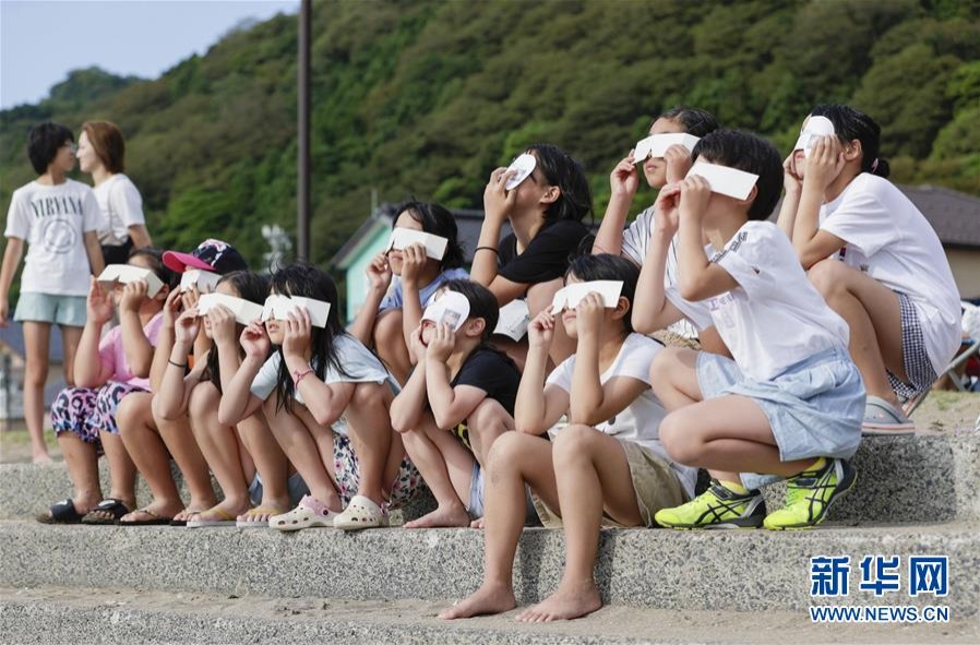 6月21日，人們在日本福井縣福井市觀看日食。新華社/共同社