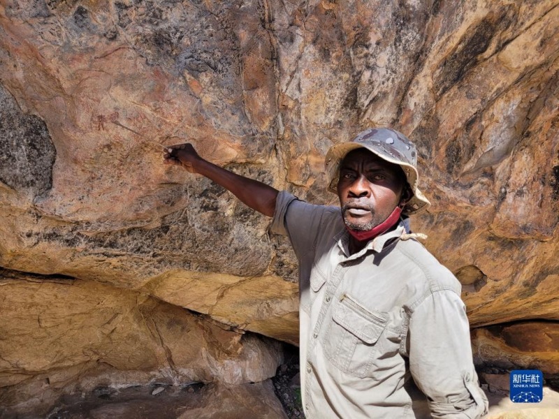 5月3日，在博茨瓦纳图利自然保护区内的莫哈巴能岩画遗址，向导曼亚查向记者介绍岩画。新华社记者 滕军伟 摄