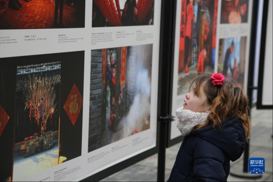 1月28日，一名小女孩在保加利亚索非亚市观看《中国春节文化图片展》。由中华人民共和国文化和旅游部、中国驻保加利亚大使馆主办的2022年“欢乐春节”《中国春节文化图片展》于当日在索非亚市斯拉维伊科夫广场开幕，展期持续21天。新华社记者 林浩 摄
