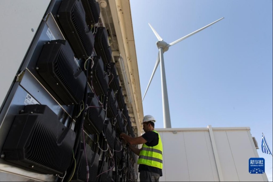 5月9日，在希臘蒂洛斯島，一名工作人員在儲存風能和太陽能的儲能電池旁工作。新華社發（馬里奧斯·羅洛斯攝）