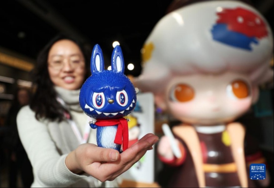 3月1日，在位于法国巴黎市中心的泡泡玛特门店，工作人员展示专门为法国消费者设计创作的ZIMOMO开业限定款玩具公仔。新华社记者 高静 摄
