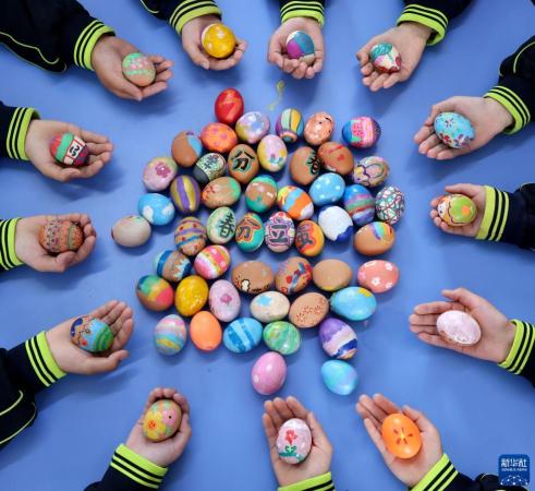 3月20日，在山东省枣庄市江山实验学校，小学生们在展示绘制的“彩蛋”。