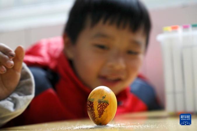 3月20日，在湖南省资兴市第一完全小学，孩子们在玩“立蛋”游戏。