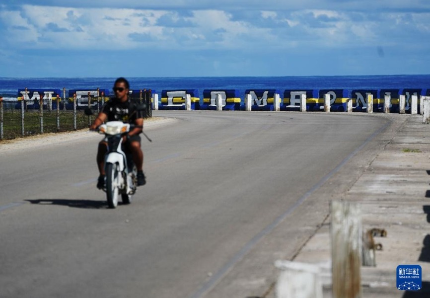 1月18日，在瑙鲁国际机场附近，摩托车行驶在海边的公路上。新华社记者 王申 摄