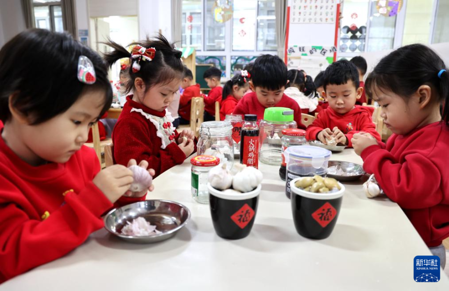1月17日，山东省滨州市滨城区清怡幼教集团第十一实验幼儿园的孩子们在学习制作腊八蒜。 新华社发（初宝瑞 摄）