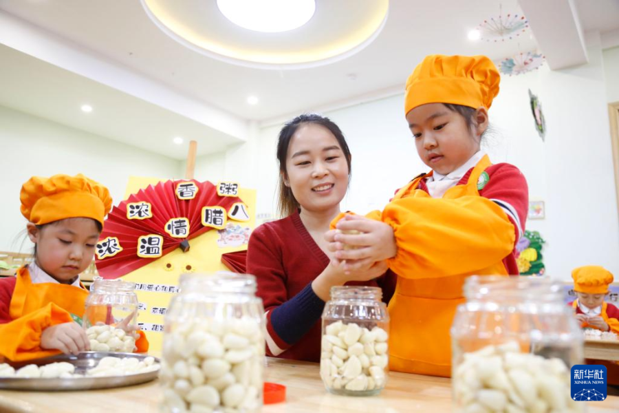 1月17日，河北省邢台市襄都区第六幼儿园的小朋友在老师的指导下制作腊八蒜。新华社发（张驰 摄）