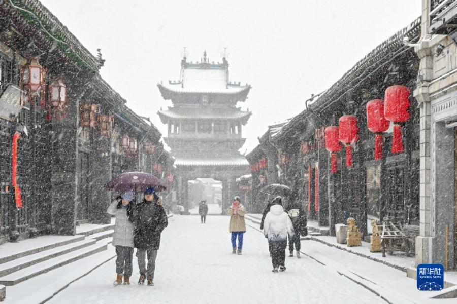 12月14日，游人在雪中游览山西平遥古城。　新华社发（梁生仁摄）