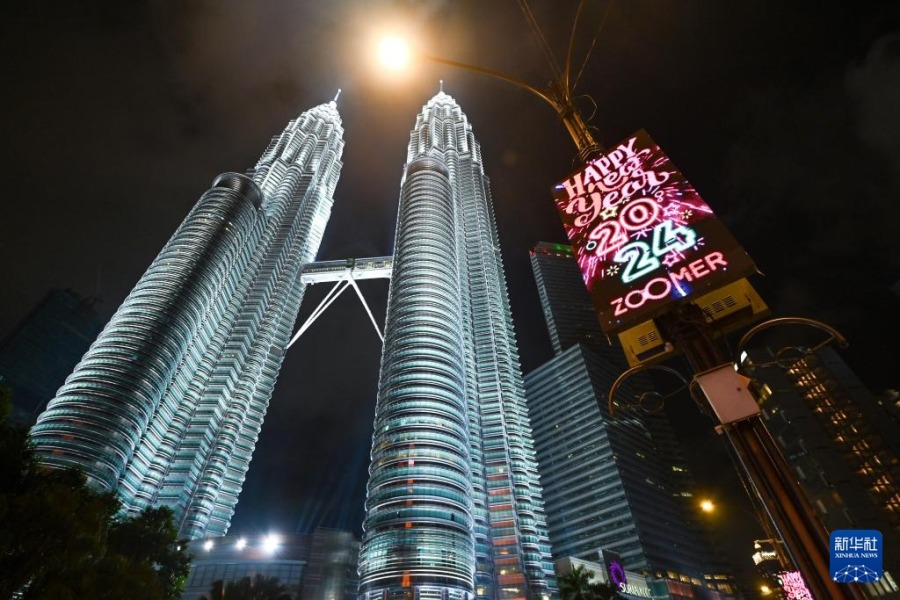 这是2023年12月31日晚在位于马来西亚吉隆坡的马来西亚国家石油公司双塔前拍摄的一块显示有“2024新年快乐”字样的广告屏。新华社发（张纹综摄）