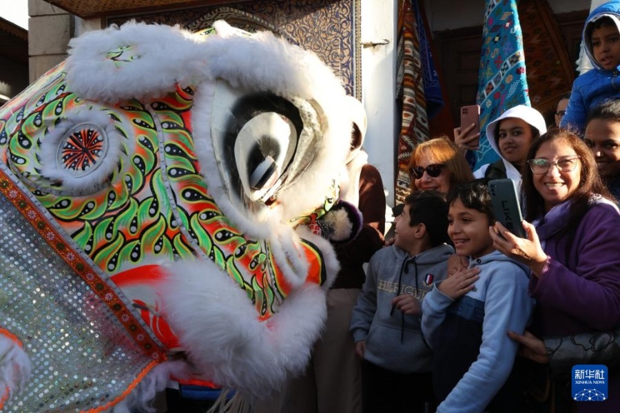 1月22日，在摩洛哥首都拉巴特老城，孩子们和舞狮演员互动。新华社记者 霍晶 摄