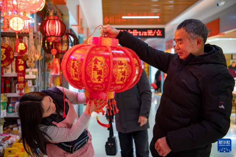 1月11日，在浙江省金华市一处农贸市场，市民选购春节饰品。新华社发（胡肖飞摄）