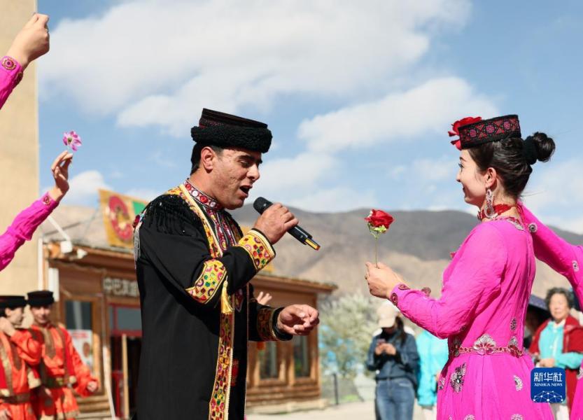 新疆塔什库尔干塔吉克自治县，塔县文工团的拜合提亚尔·居马汗为游客演唱《花儿为什么这样红》，妻子古丽巴努尔·库尔恰克在一旁伴舞（9月4日摄）。新华社记者 兰红光 摄