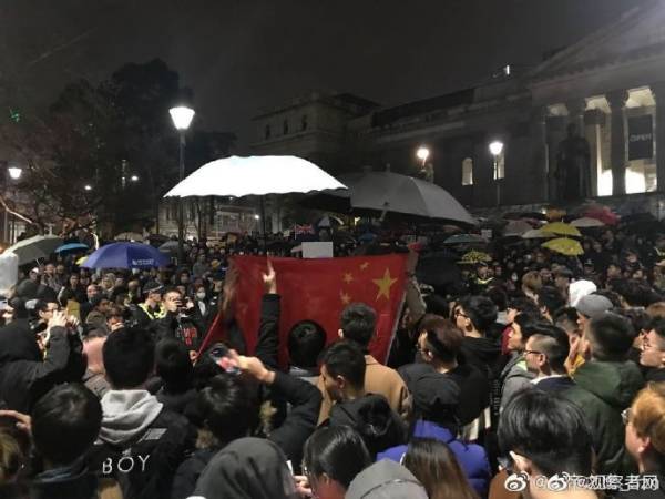 中国留学生高唱国歌压制“港独” 冒雨为国旗撑伞