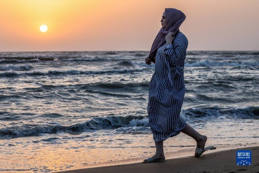 8月21日，一名女子在俄罗斯达吉斯坦共和国马哈奇卡拉市的海滨散步。新华社/塔斯社