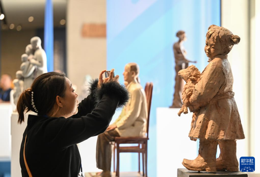 10月14日，观众在首届呼和浩特国际雕塑艺术展上拍摄雕塑作品。