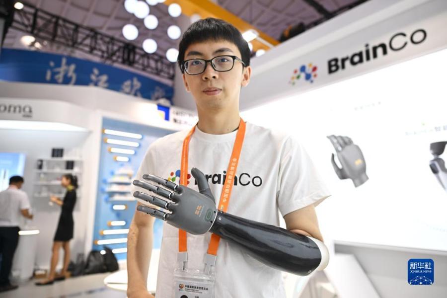 4月10日，参展商在浙江展台展示一款智能仿生手。新华社记者 郭程 摄