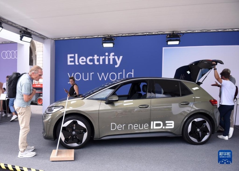 9月13日，观众在奥地利维也纳电动汽车日活动现场参观一辆大众电动车。新华社记者 贺灿铃 摄