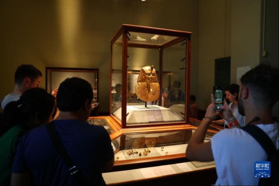 10月5日，在位于埃及开罗的埃及博物馆，游客拍摄法老苏瑟奈斯一世的金面具。新华社记者 隋先凯 摄