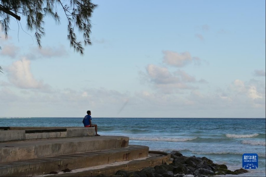 5月29日，一名男子坐在巴巴多斯首都布里奇敦的一处海岸边。新华社记者 辛悦卫 摄