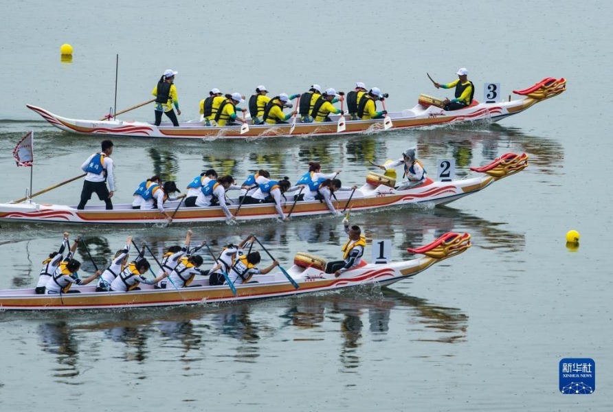 5月27日，人们在三峡大坝前的湖北省秭归县水域参加龙舟竞渡。新华社发（郑家裕 摄）