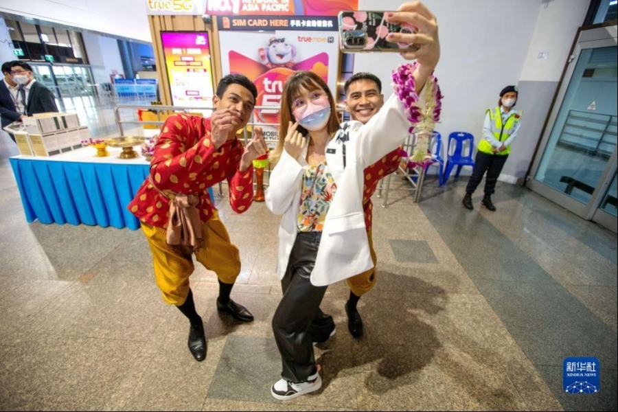 2月6日，在泰国曼谷廊曼国际机场，一名中国游客与工作人员自拍。新华社记者 王腾 摄