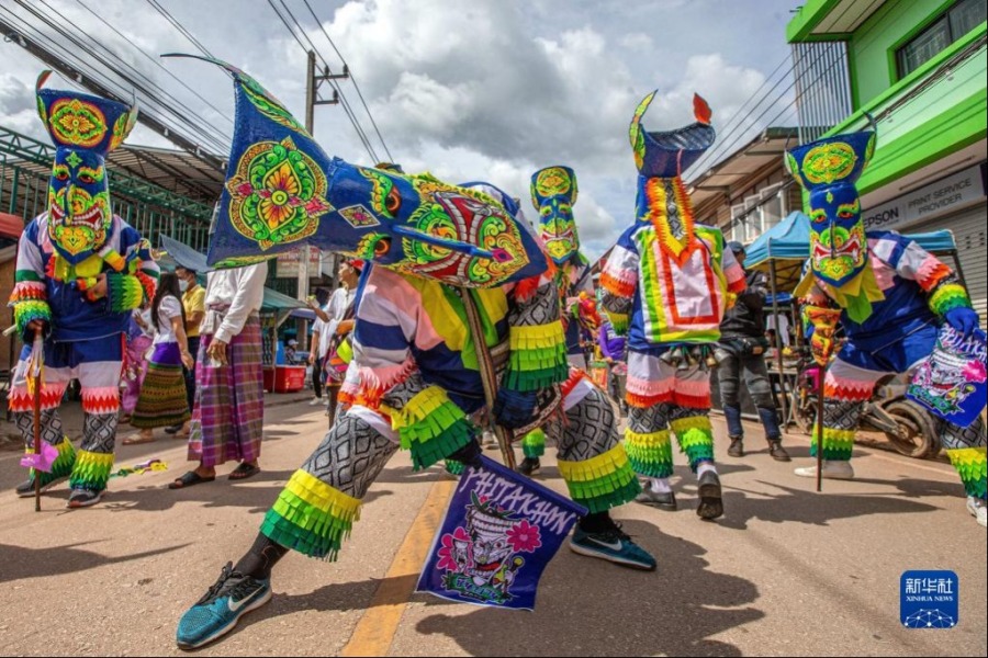 7月1日，在泰国黎府，人们头戴面具载歌载舞。新华社记者 王腾 摄