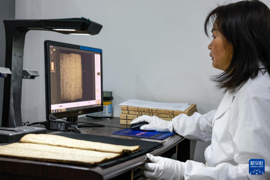 3月8日，荔波县档案史志馆的工作人员在用扫描仪录入水书文献。