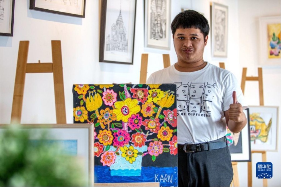 4月2日，在位于曼谷的泰国孤独症职业中心，一名孤独症患者展示自己的绘画作品。新华社记者 王腾 摄