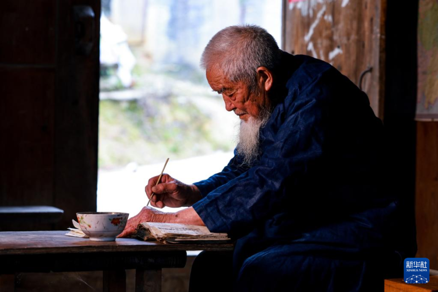 3月10日，水书先生潘秀业在家中书写水书文字。