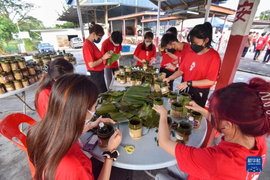 1月8日，在马来西亚首都吉隆坡以北约70公里的新古毛，工作人员在准备盛放年糕的竹筒。新华社发（张纹综摄）