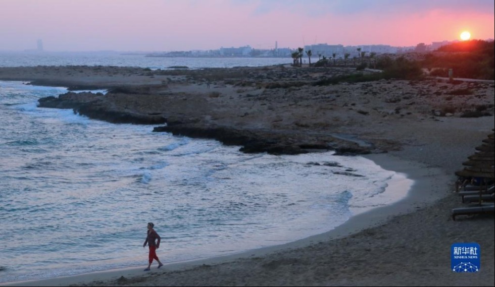 这是6月26日在塞浦路斯圣纳帕“爱之桥”附近拍摄的海边落日。新华社记者 郭明芳 摄