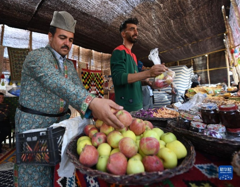 10月5日，在伊朗首都德黑兰，两名男子售卖商品。新华社记者 沙达提 摄