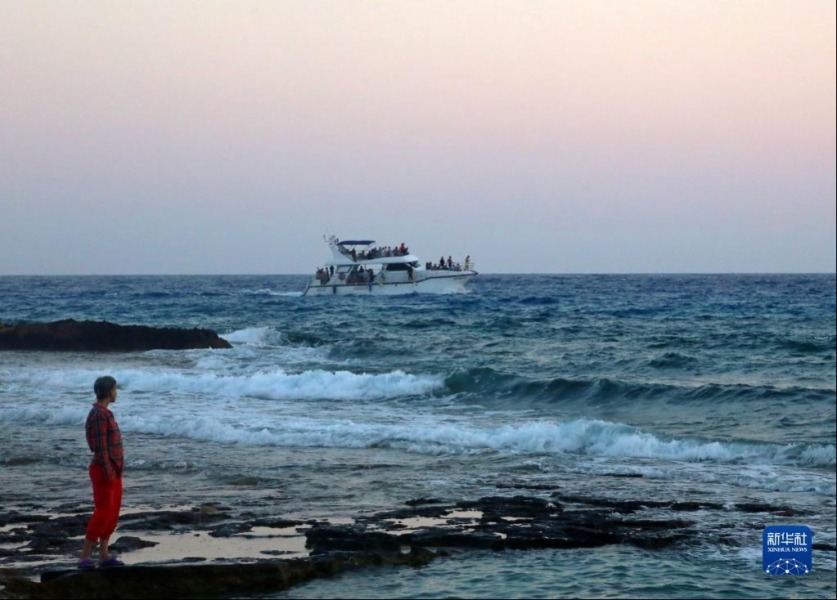 6月26日，一名男子站在塞浦路斯圣纳帕“爱之桥”附近的海滨。新华社记者 郭明芳 摄