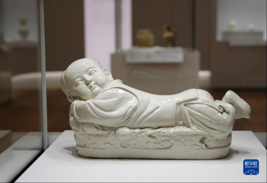 6月28日在香港故宫文化博物馆拍摄的北宋定窑白釉孩儿枕。新华社记者 王申 摄