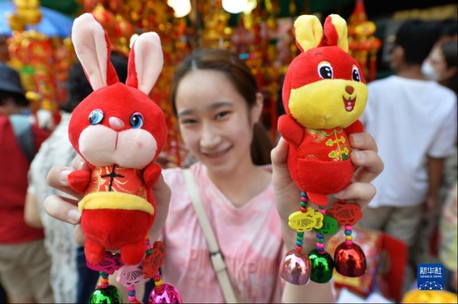 1月16日，一名顾客在泰国曼谷唐人街展示春节饰品。新华社发（拉亨摄）