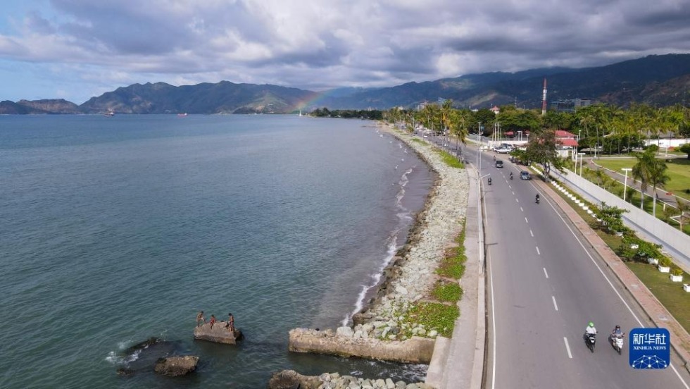 6月6日，在东帝汶首都帝力，一道彩虹出现在海边（无人机照片）。 新华社记者 徐钦 摄