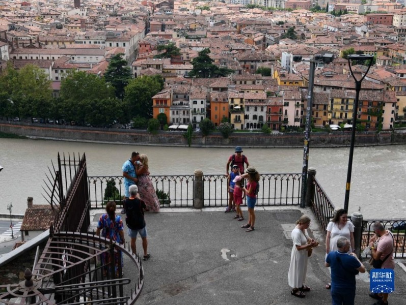 8月3日，游客在意大利维罗纳阿迪杰河畔观光。新华社记者 金马梦妮 摄