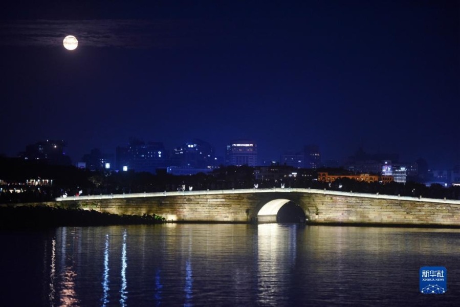 9月10日晚，游客在杭州西湖断桥上赏月。新华社发（龙巍 摄）