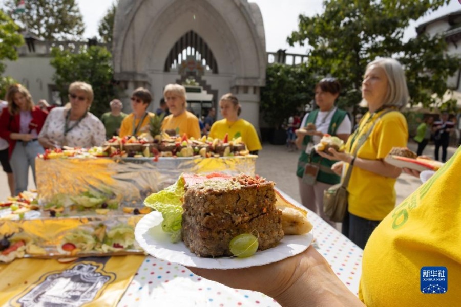 8月9日，在匈牙利布达佩斯动物园，人们品尝特制蛋糕。新华社发（弗尔季·奥蒂洛摄）