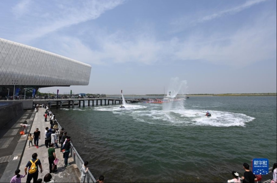 5月3日，游客在位于天津市滨海新区的国家海洋博物馆室外观看水上特技表演。新华社记者 赵子硕 摄