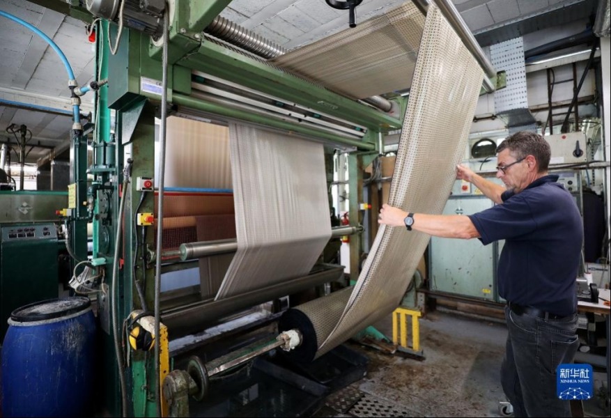 8月11日，工人在英国麦克尔斯菲尔德一家丝绸工厂内工作。新华社记者 李颖 摄