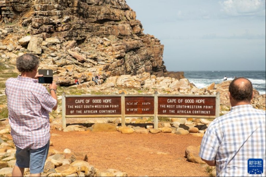 10月27日，在南非开普敦桌山国家公园的好望角区域，游客拍摄指示好望角位置的指示牌。新华社记者 吕天然 摄
