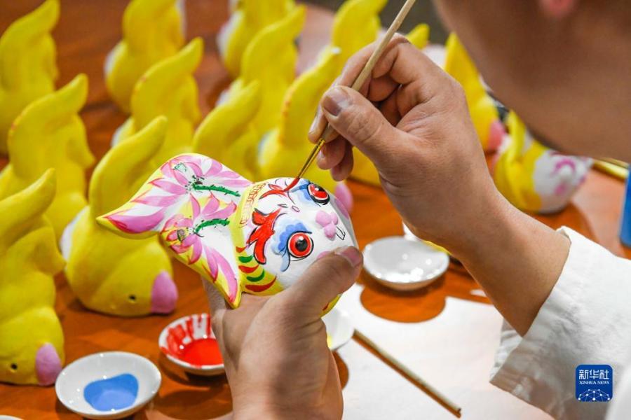 1月16日，河北省玉田县一家泥塑工坊的民间艺人在给生肖兔作品着色。