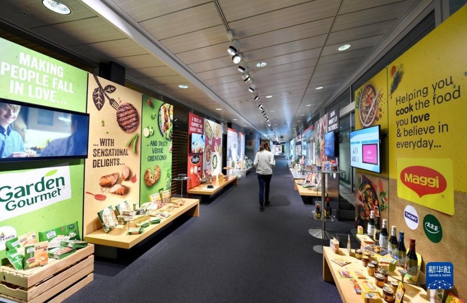 10月31日，在瑞士沃韦的雀巢总部，工作人员走过全球产品展示廊。新华社记者 连漪 摄